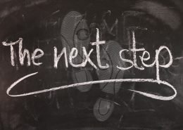 Schiefertafel mit der Kreide-Aufschrift "The next Step"